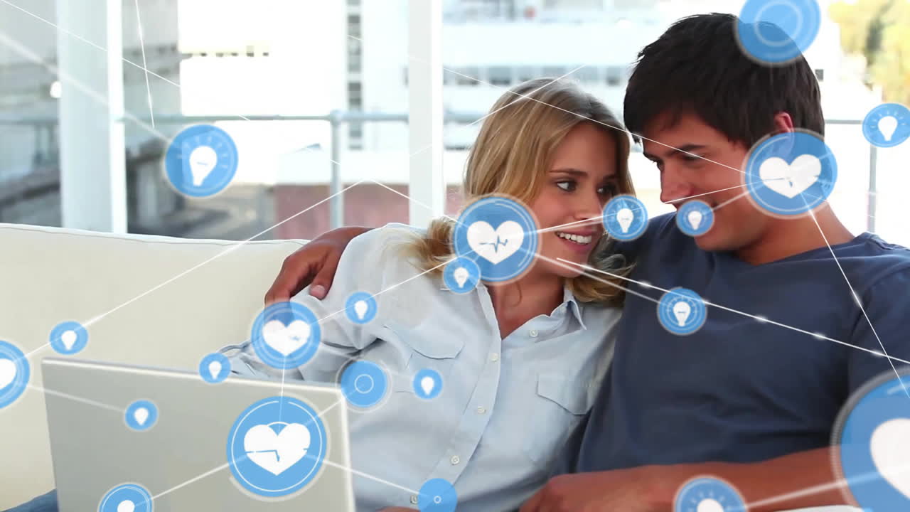 animación de la red de conexiones con iconos sobre pareja caucásica usando portátil