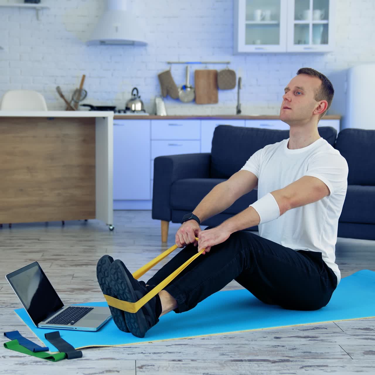 Man doing exercise with online tutorial. Attractive young man doing exercising at home
