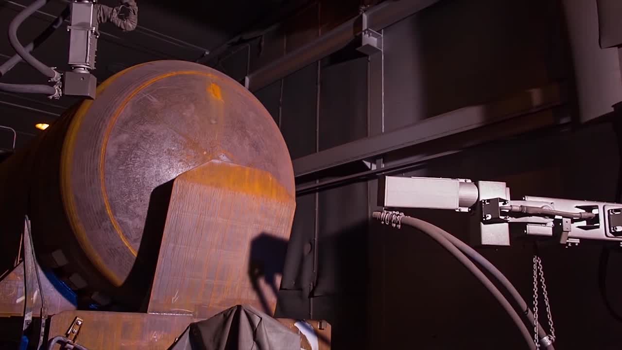 robot industriale che ispeziona un grande serbatoio metallico