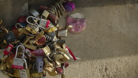 Close-up-love-locks,-rack-focus-boat-driving-under-the-bridge-of-arts-in-Paris