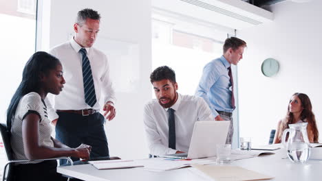 Slow-Motion-Shot-Of-Businessmen-And-Businesswomen-Meeting-Around-Table-In-Modern-Boardroom-Working-On-Laptop-Together