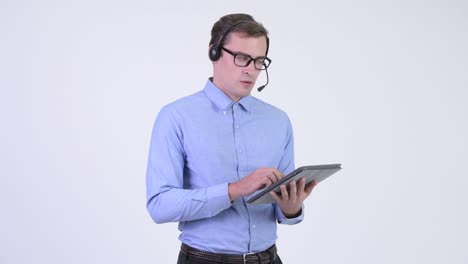 joven empresario estresado como representante del centro de llamadas usando una tableta digital