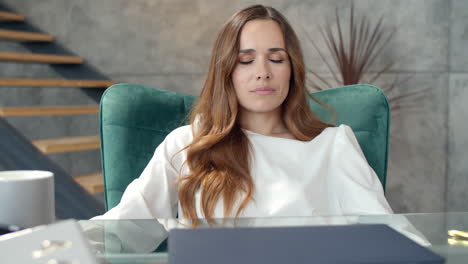 Portrait-of-tired-business-woman-calming-down-at-remote-workplace.