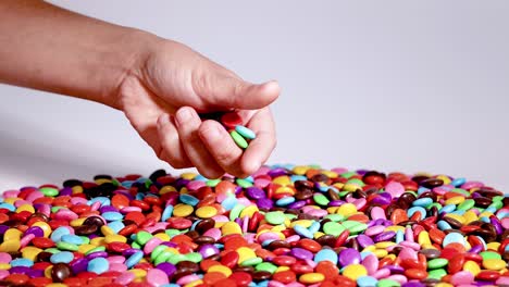 hands sorting colorful candies on a table