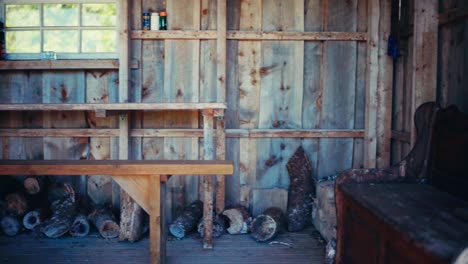 the interior of a wooden cabin, featuring chopped logs and a worn wooden couch, along the route from seterdjupna to malitjønna in indre fosen, trøndelag, norway - handheld shot