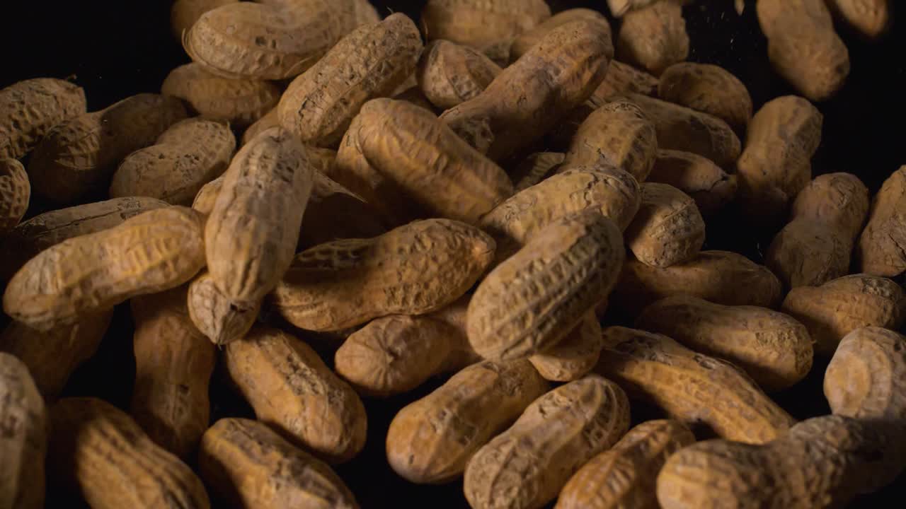 Peanuts in shells fall in slow motion