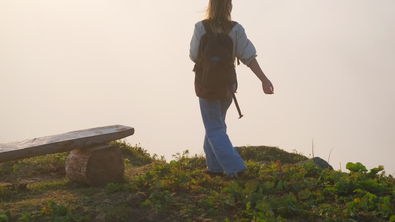 una mujer caminando por las montañas de niebla.
