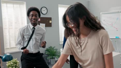 dance at work, office, break from duties, company party, two girls and a man in a shirt and tie dancing together, fooling around, laughing, smiling, relieving stress, music playing from the computer