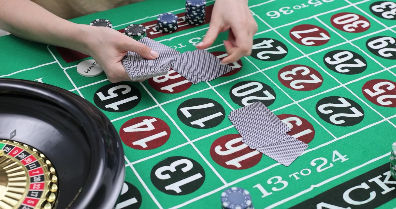 Donna distribuisce carte da gioco a faccia in giù su un tavolo da roulette verde