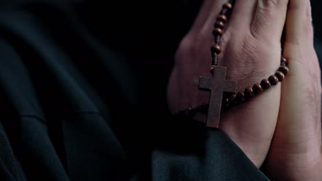 close-up of worshiper's hands with beads, person saying prayer, christian faith