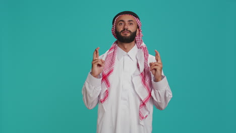 arab person poses with fingers crossed