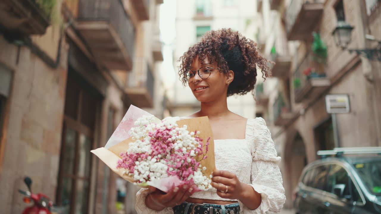 Woman with bouquet on city street