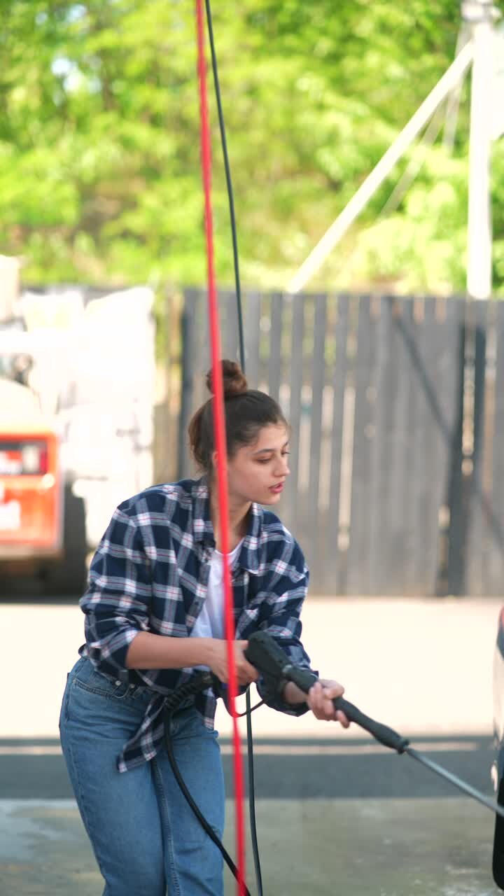 Woman Washing a Car at a Self-Service Car Wash