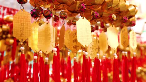 hanging golden bells with red tassels sway gently