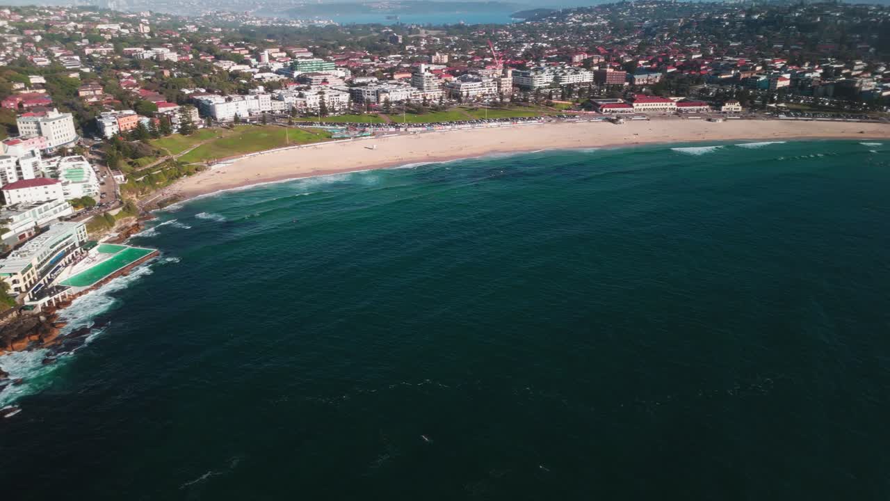 imágenes de drones que destacan la playa de bondi, la piscina de icebergs y el suburbio costero circundante con vegetación vibrante y olas claras del océano. capturado en 4k a 25 fps.