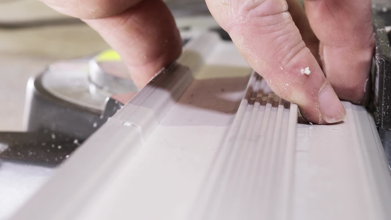 рабочий режет подставку на круговой пиле перед установкой.