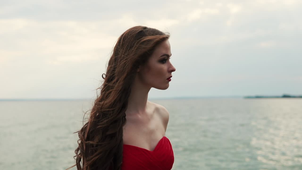 Woman in red dress by the sea
