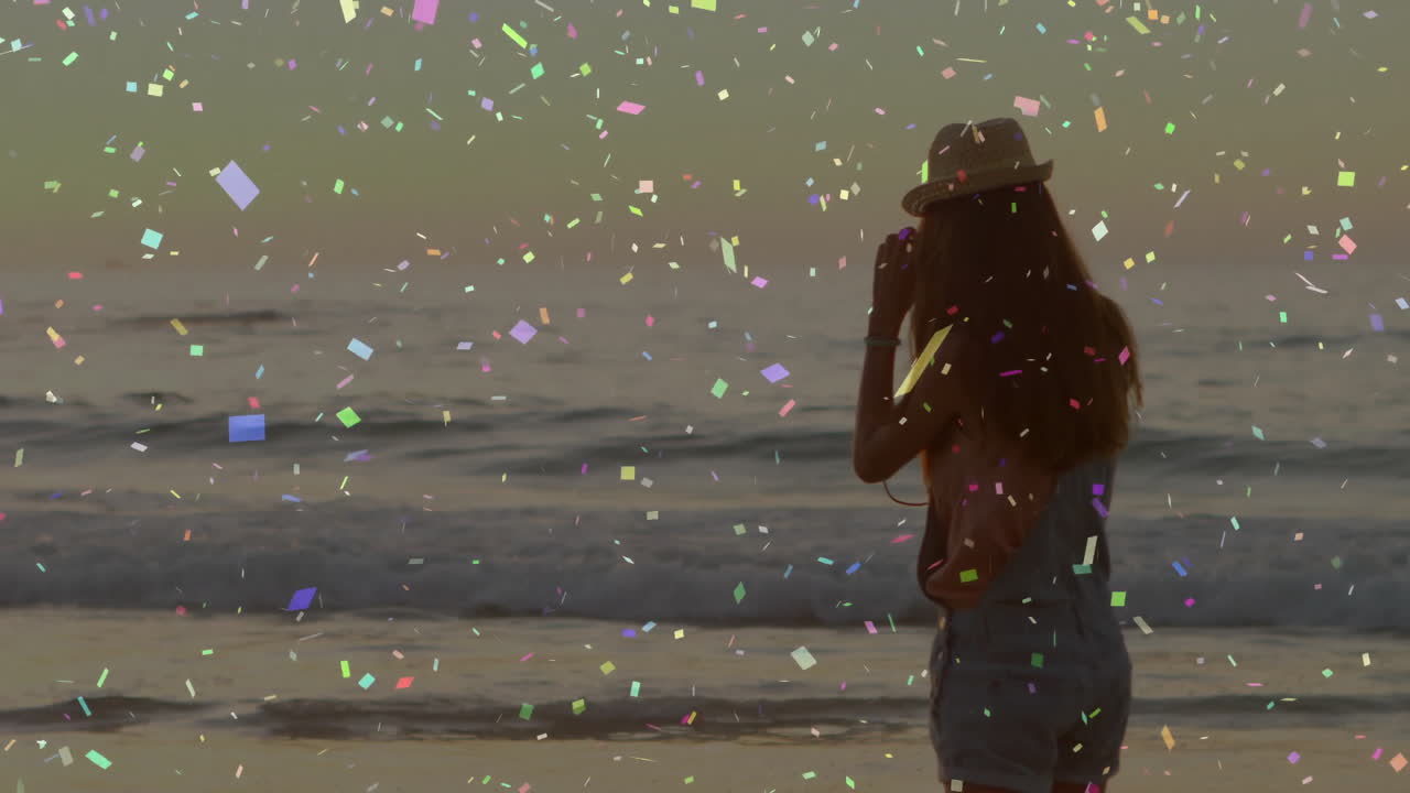 Silhouette of person on beach with colorful confetti animation over ocean