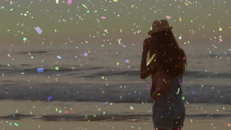 silhouette of person on beach with colorful confetti animation over ocean