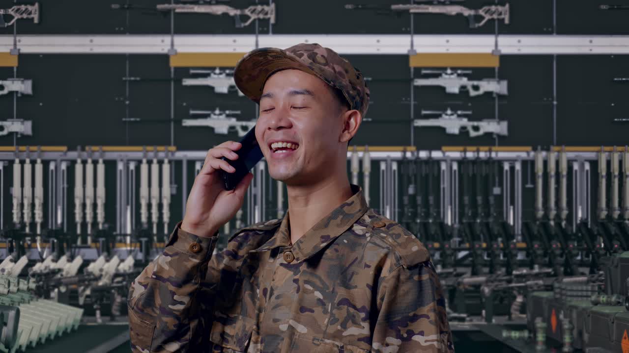 Primo piano di un soldato che parla al telefono e si guarda intorno in un deposito militare, vista laterale