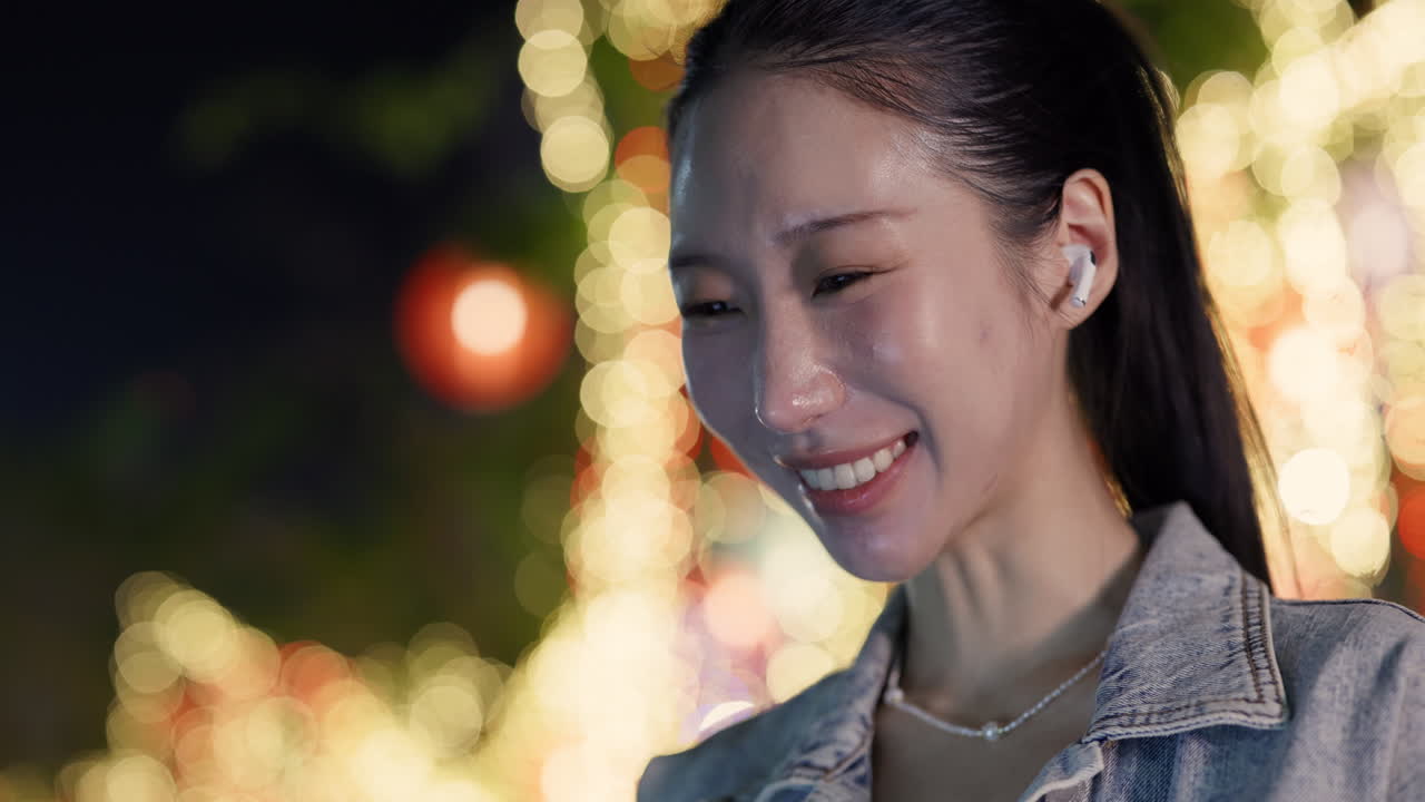 Portrait of a woman with earbuds at night