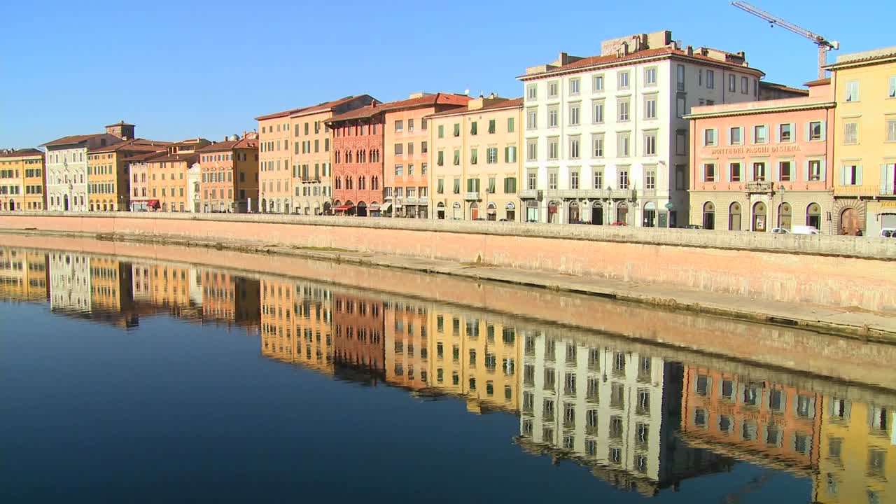 Gli edifici si allineano e si riflettono in un canale simmetrico a Pisa, Italia 1