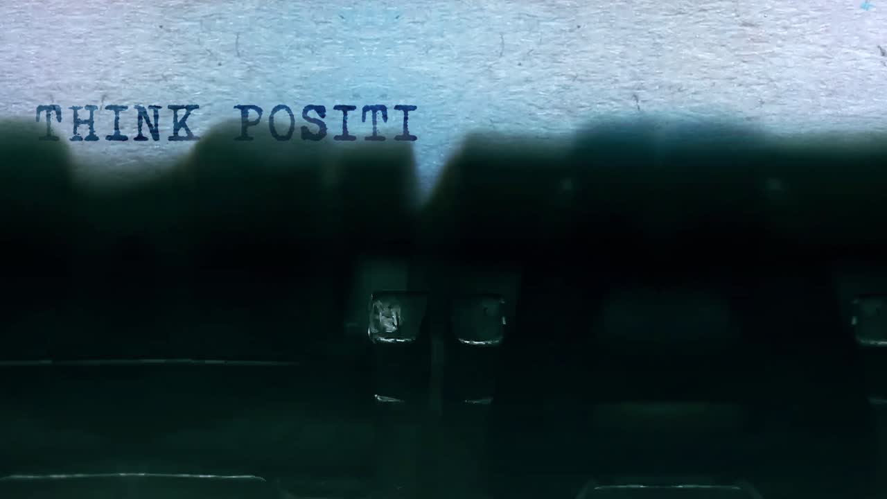Think positive word closeup being typing and centered on a sheet of paper on old vintage typewriter