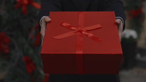 person holding a red gift box