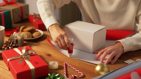 Woman-showing-Christmas-gift-wrapped-in-craft-paper-with-red-bow.-Vertical-video.Woman-showing-Christmas-gift-wrapped-in-craft-paper-with-red-bow.-Smiling-female-is-holding-New-Year-present-box.-Celebrating-Merry-Christmas-or-Happy-New-Year-2025.-Vertical-video