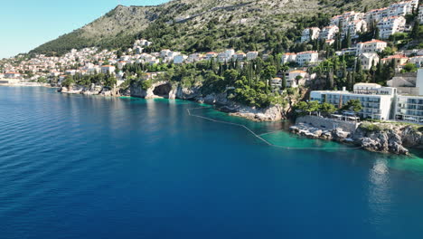 Low-aerial-views-over-the-sea-cliffs-and-sea-cave-near-Dubrovnik,-Croatia