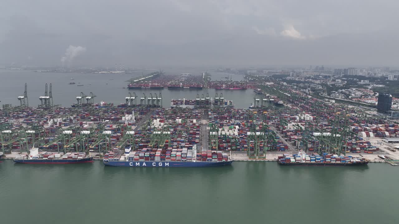 Aerial View of a Bustling Global Shipping Port with Numerous Container Ships and Stacks of Cargo