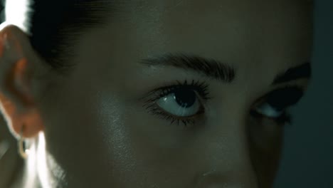 smooth push-in toward a woman’s eyes from a slight profile angle as she cycles intensely, eyes locked forward in deep concentration. soft cinematic light enhances her focus and facial tension