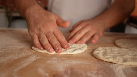 baker shaping dough for flatbread