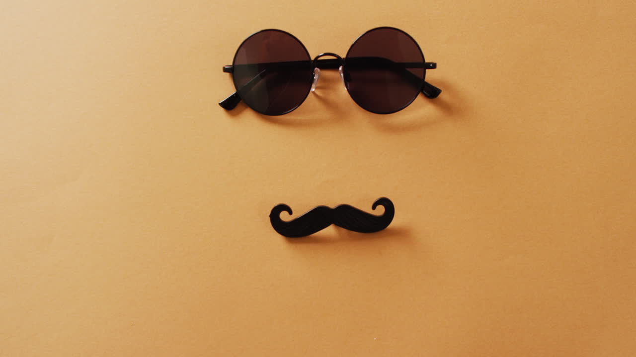 video de bigote falso y gafas de sol redondas sobre fondo amarillo con espacio para copiar.