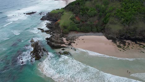 Cabecero-Y-Océano-En-Broken-Head-Beach,-Byron-Bay,-Nueva-Gales-Del-Sur,-Australia---Retroceso-Aéreo