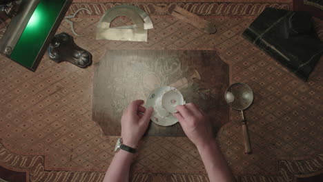 an older man evaluates an old porcelain