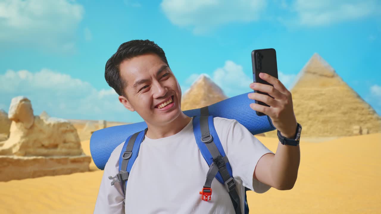 Man taking a selfie in front of pyramids in Egypt