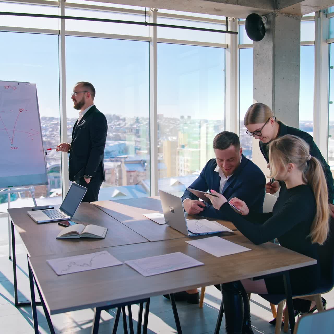 Teamwork of business people in office. Group of entrepreneurs work together about business blueprint on the background of city view from the skyscraper