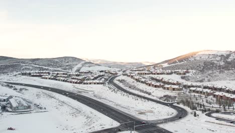 Vista-Aérea-Del-Amanecer-Parque-Cubierto-De-Nieve-Ciudad-Utah,-Intersección-De-Autopista