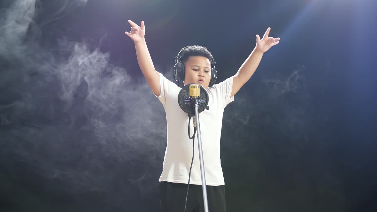 어린 소년 이 마이크 로 노래 하고 있다