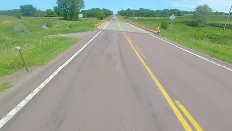 pov a través de la ventana de visión trasera mientras conduce por una carretera del condado en la zona rural de dakota del sur