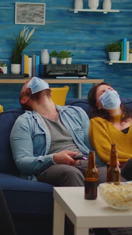 vertical video: group of multi ethnic friends watching comedy show on tv laughing