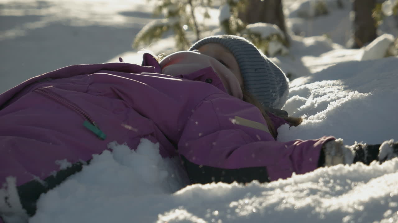 movimiento lento de una joven caucásica haciendo ángeles de nieve