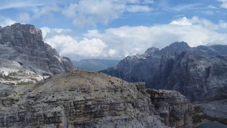 4K-footage-of-a-young-hiker-standing-on-a-mountain-peak-with-a-view-of-the-impressive-landscape-of-the-Dolomites-in-North-Italy