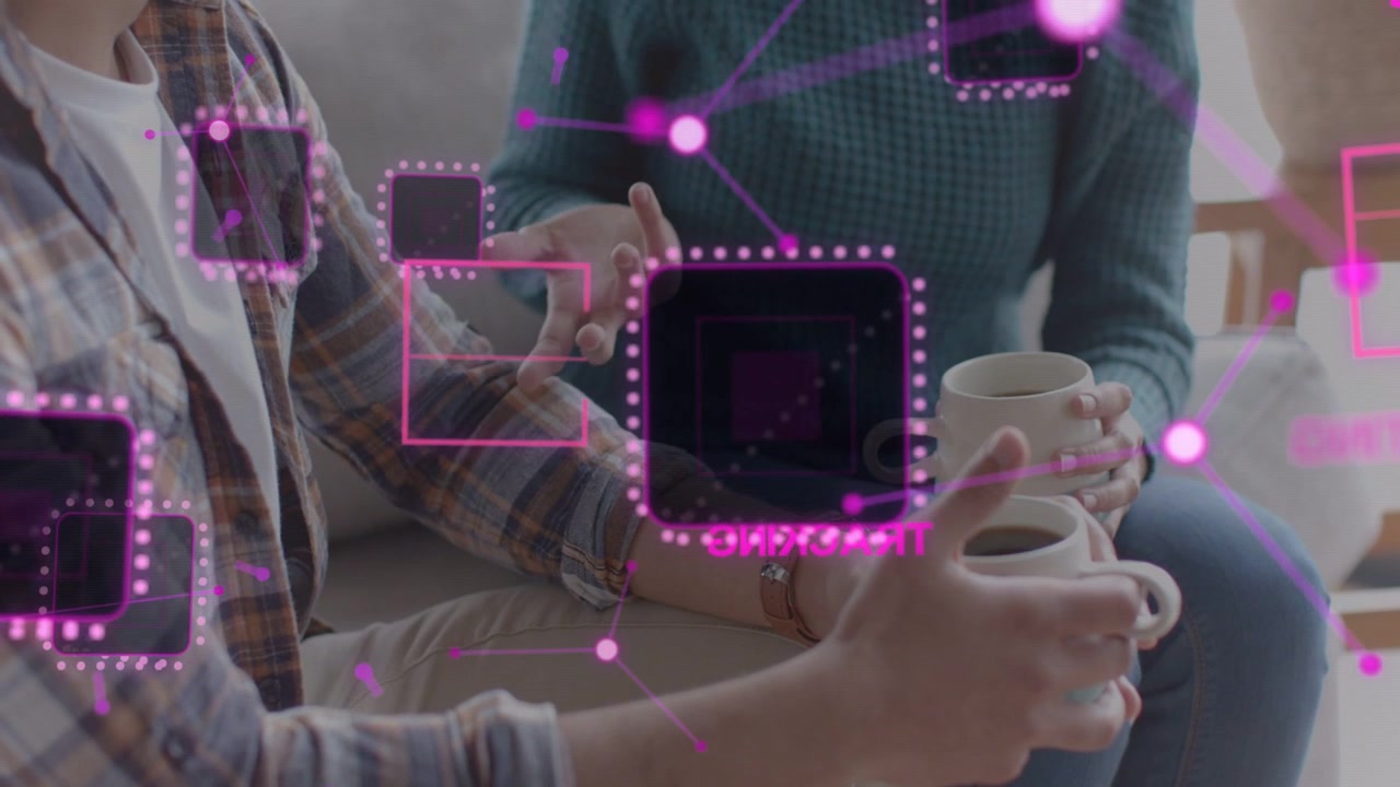 Couple sitting couch holding mugs while right person gesturing magenta network overlay showing data
