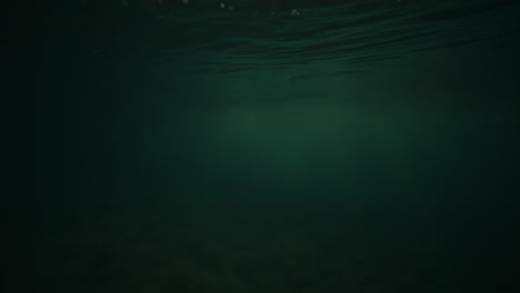 Bokeh-light-bubbles-reflect-on-ocean-water-surface-at-sunrise