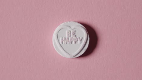 heart candy with be happy message on pink background