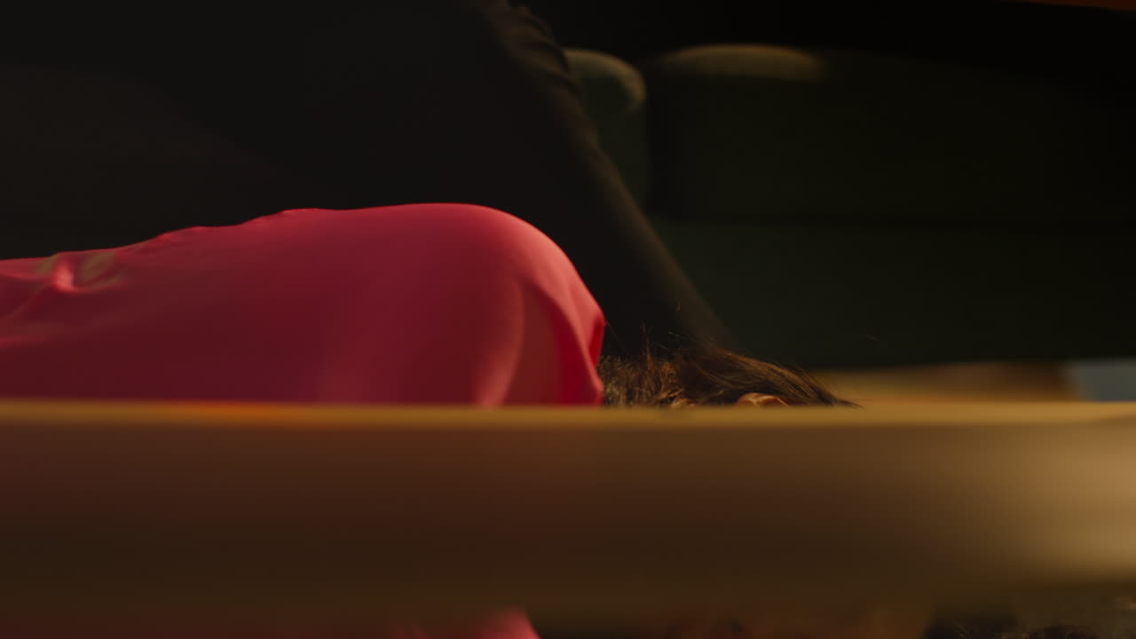 Couple Lying Passed Out On Sofa And Floor After Drinking Alcohol At House Party Suffering With Hangover