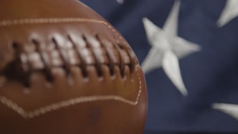 focus pulls from close up shot of american football to stars and stripes flag 2