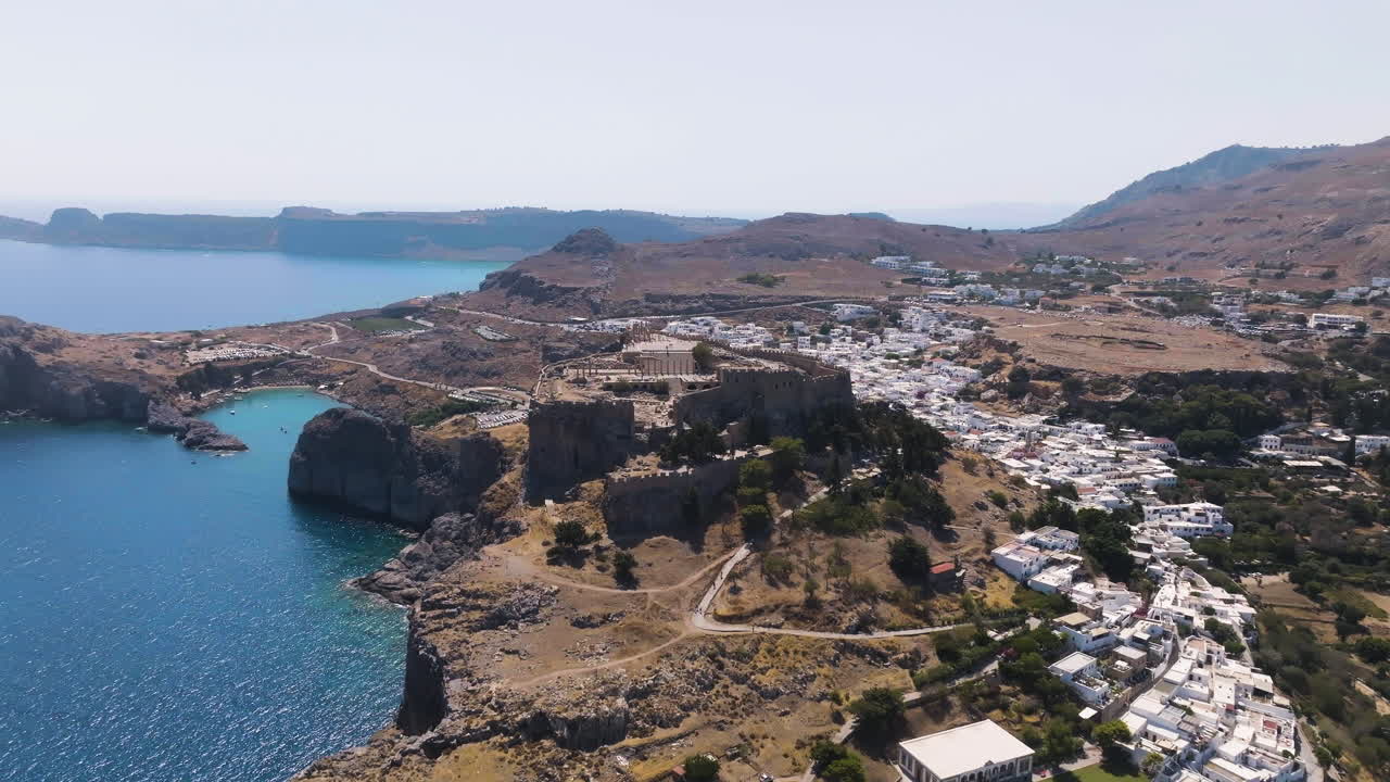 Establishing drone shot of the Acropolis of Lindos, sunny day in Rhodes, Greece